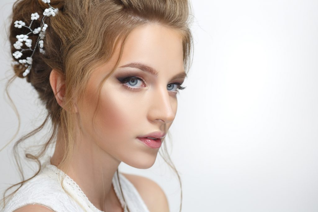 Pretty bride with a gentle make-up isolated on a gray background